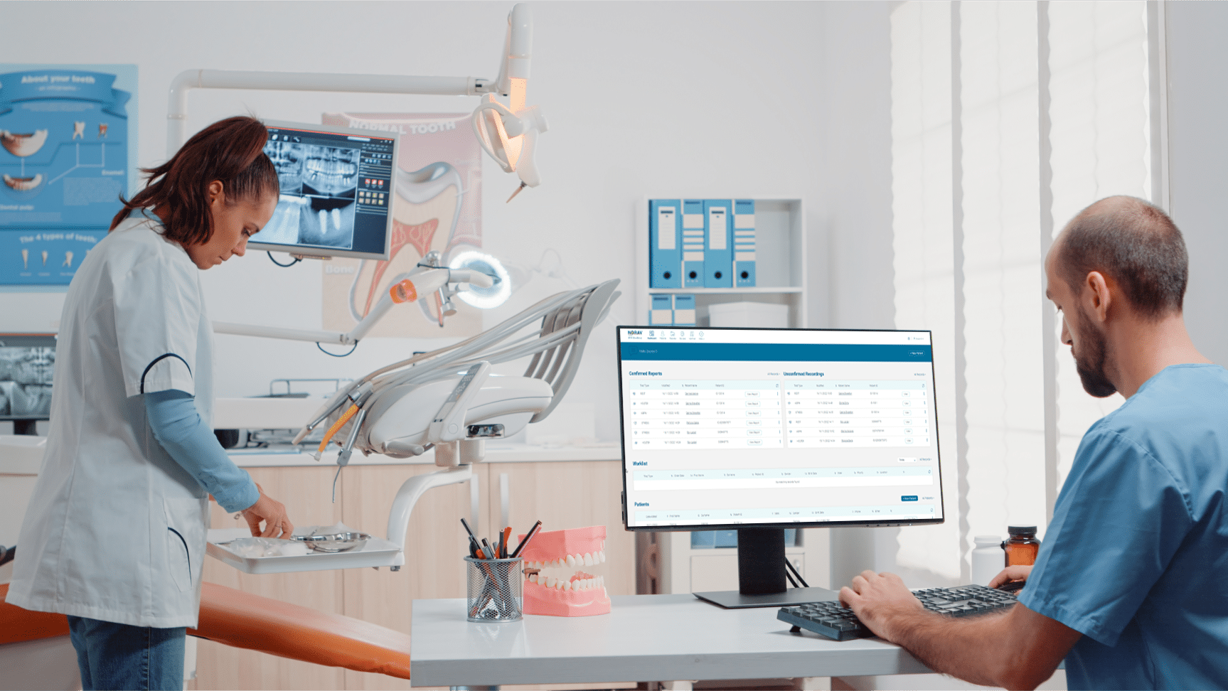 the doctor is sitting at the computer, a nurse is standing next to him